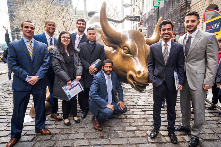 Business administration students pose with the iconic Charging Bull in Manhattan's Financial District. 