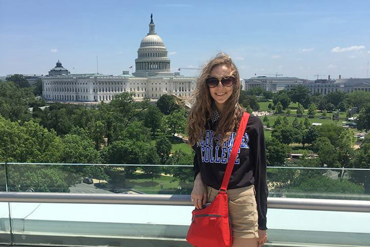 Ayla Cordell stands in front of the D.C. skyline.