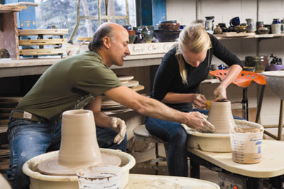 Dave Ernster assists senior Kate Rial as she shapes a vessel on the throwing wheel. 'The thing that draws me to the art of ceramics is the feeling of clay between my hands — how one can manipulate it into anything they wish, and then recycle it to create something completely new, excites me and allows me to make mistakes and challenge myself as an artist,' says Rial