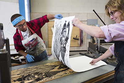 Will Shearer and Professor Mead lift a print from his woodcut block.