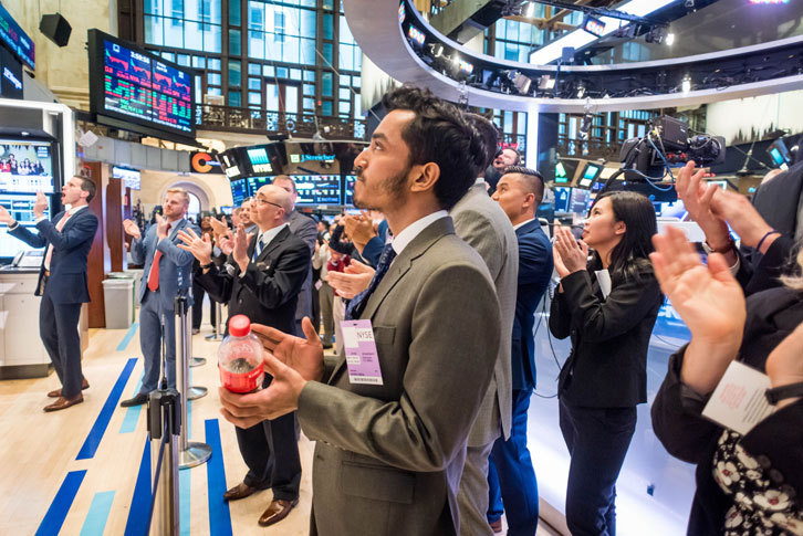 Business administration students clapping during the closing bell at the New York Stock Exchange.  