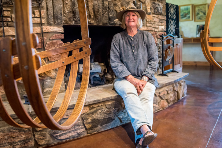 Joan Montagne sits on her fireplace's hearth. 