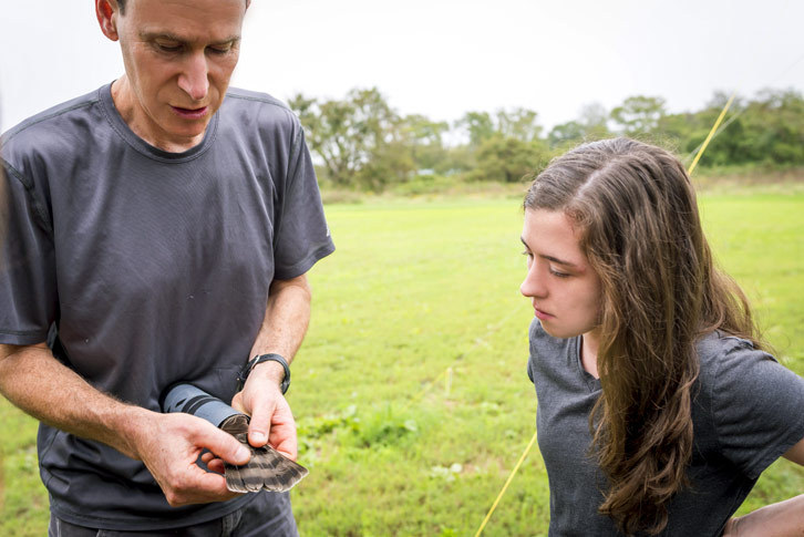 Professor Nick Baer and Taylor Spadafora ’20 examining raptors tail feathers